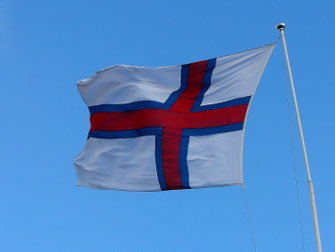 Die weiße-blau-rote Färöer Flagge weht im heftigen Wind.