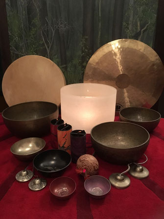 A collection of sound healing instuments, singing bowls, tingshals, drum, gong, rattles