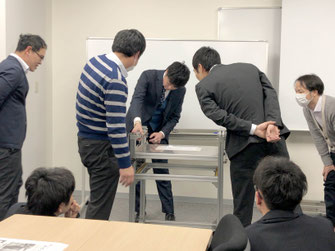 写真3:実機をもとに製作者が改善した個所を具体的に参加者に紹介されている風景