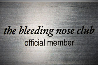 Close-up of  logo- The bleeding nose club- on a stainless steel stand