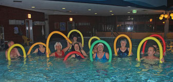 Wassergymnastikgruppe mit Poolnudeln in Aktion