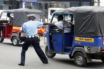 Agente del traffico alle prese con il conducente di un tuk-tuk che cerca di scappare