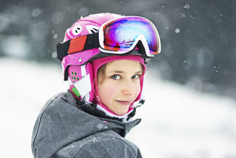 Young girl in pink ski helmet and goggles