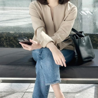 脚を組んで椅子に座る女性
