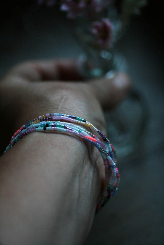 Hand mit einem bunten Armband aus Perlen, Perlenschmuck, Detailaufnahme von handgemachtem Schmuck,
