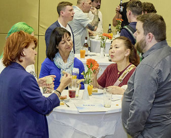 Tischrunde in angeregtem Gespräch während der Veranstaltung