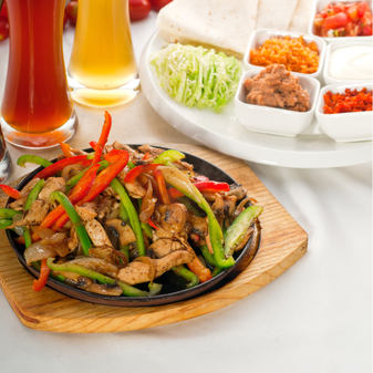 Plate of sauteed chicken and veggies with fajitas toppings