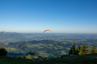 Gleitschirmflieger fliegt von der Hochries ins Inntal