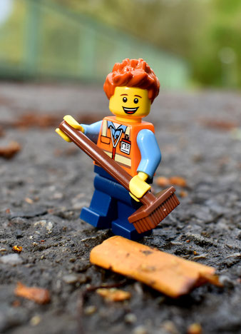Legofigur mit Besen, Umweltschutz, freudiges Gesicht