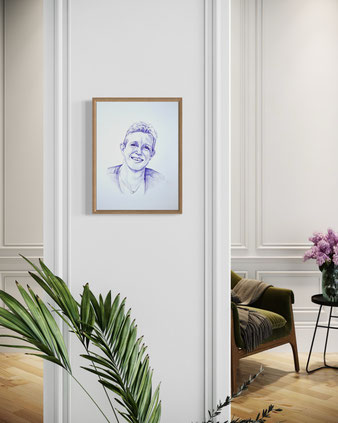 Met pen getekend portret van een lachende vrouw, realistisch weergegeven en ingelijst aan een witte muur in een stijlvol interieur met klassieke wandpanelen, een groene fauteuil en planten.