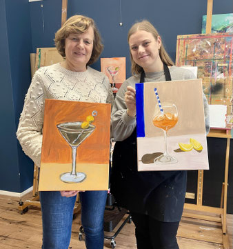 Moeder en dochter tonen trots hun kunstwerken gemaakt tijdens een gezellige creatieve workshop in Breda.