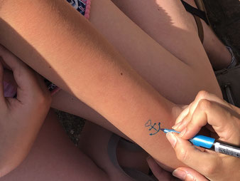 Tattoo wird auf den Arm gezeichnet