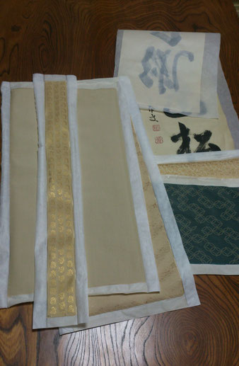 《掛軸工程 裂肌裏打ち（きれはだうらうち）》掛け軸を仕立てる為に、本紙の周りに使う裂の裏に和紙を貼り補強します。