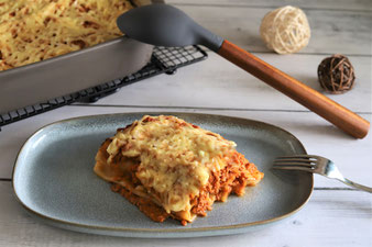 Mit Käse aus der Microplane Reibe bestreuen