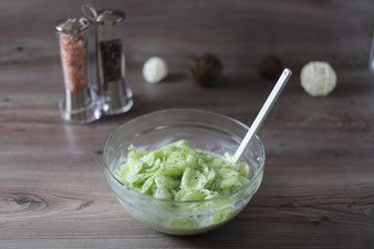 Gurkensalat in der mittleren Glasschüssel mit kleiner Küchenhobel und Gemüseschäler sowie Salz und Pfefferstreuer aus dem Pampered Chef Onlineshop
