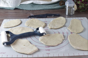 Teig auf der Teigunterlage mit dem Teigroller ausrollen