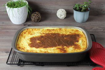 Auflauf in der Ofenhexe mit Kuchengitter und Packs an Handschuhen von Pampered Chef