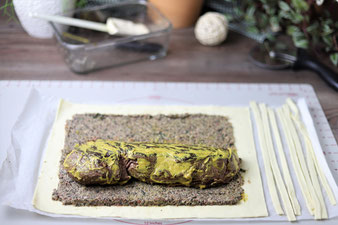 Rinderfilet in Blätterteig auf der Teigunterlage einwickeln