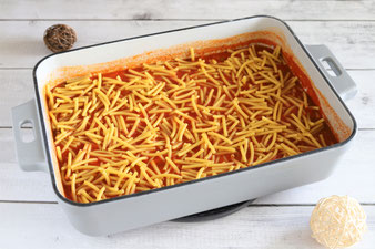 Ungekochte Nudeln zur Tomatensoße geben