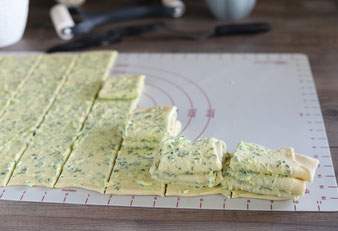 Hefeteig mit dem Teigroller auf der Teigunterlage von Pampered Chef ausrollen und mit dem Nylonmesser in Streifen schneiden