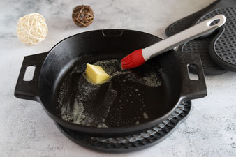 Butter in der 25 cm gusseisernen Pfanne mit dem Silikonpinsel verstreichen