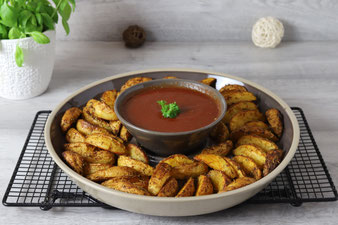 Kartoffelwedges mit BBQ Sauce in der kleinen Servierschüssel und Servierplatte