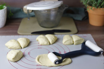 Teig auf der Teigunterlage von Pampered Chef mit dem Nylonmesser schneiden und mit dem Teigroller ausrollen