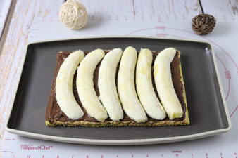Nutella und Bananen auf dem Teig verteilen