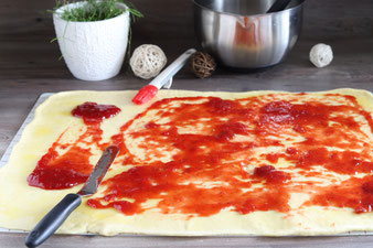 Butter mit Silikonpinsel einstreichen und Marmelade mit kleinem Streicher bestreichen