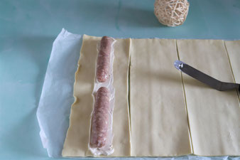 Bratwurst auf dem Blätterteig verteilen