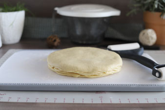 Teigplatten auf dem Schneidebrett übereinander legen