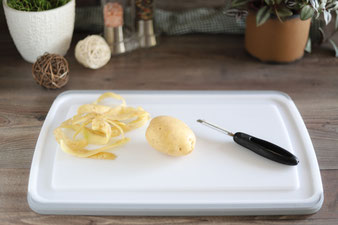 Kartoffeln schälen mit dem Gemüseschäler von Pampered Chef auf dem Schneidebrett mit Saftrillen