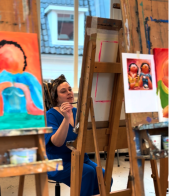 Deelnemer aan de ‘Dikke Dames’-schilderworkshop van Daphne Schrijver, geconcentreerd aan het werk in groepsverband in haar atelier.