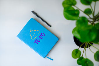 Blaues Notizbuch mit Aufschrift To-Do auf Schreibtisch – Aufgabenplanung im Gewässerschutzmanagement