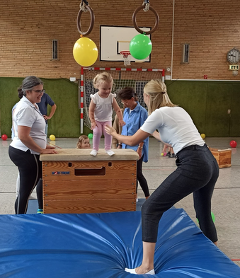 Foto: Kind springt vom Kasten auf die Matte