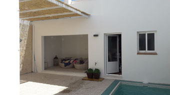 Pergola con caña en un patio con una piscina pequeña