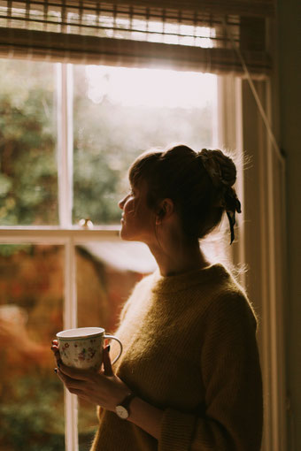 Frau am Fenster mit Teetasse