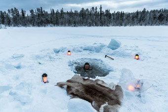 Eisbaden im zugefrorenen See direkt vor dem Ferienhaus in Ranua, Lappland – Wintererlebnis mit Sauna und arktischer Natur