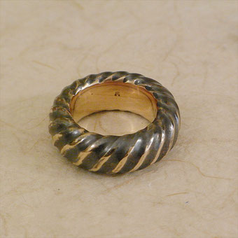 Fingrring aus Bronze mit Spilralmuster. Die Ringschiene ist Spiralförmig gestaltet. Von Gunter Schmidt Bildhauer.