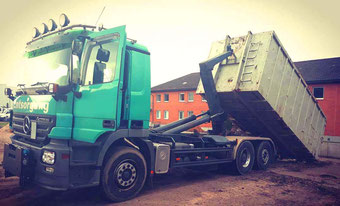 Mercedes Benz Actros Abrollkipper mit Container des Containerdienstes de Casê vor Wohngebäude in Hessen