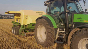 Deutz-Fahr K610 Traktor mit Krone Quaderballenpresse bei der Strohpressung auf Feld in Hessen.