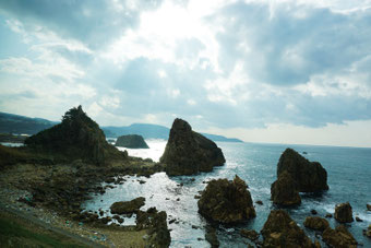 奇岩に囲まれた行合崎海岸沿いを列車は走行していく