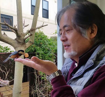 筆者（手乗りするヤマガラ🐦とのツーショット）