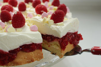 HimbeerTorte mit Quarkcreme, ein Stück wurde angeschnitten