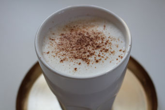 ein Becher Chai Latte mit Schokopulver