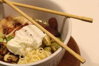 Ramen Suppe auf eienm Brettchen, Stäbchen liegen auf dem Rand