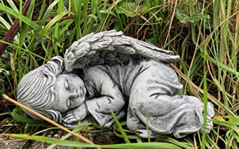 Kleine Engel Skulptur liegend in Wiese