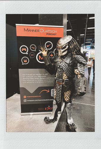 Das Titelbild zu Männerquatsch Podcast Folge 174 (Gamescom 2024 - Rückblick und Interviews) zeigt ein geniales Predator Cosplay. 
