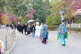 山梨県武田神社結婚式神殿に向かうシーンの写真です　新郎新婦の表情が和やかです