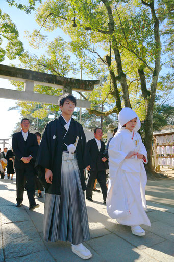 山梨県武田神社結婚式神殿に向かうシーンの写真です　新郎新婦の表情が和やかです